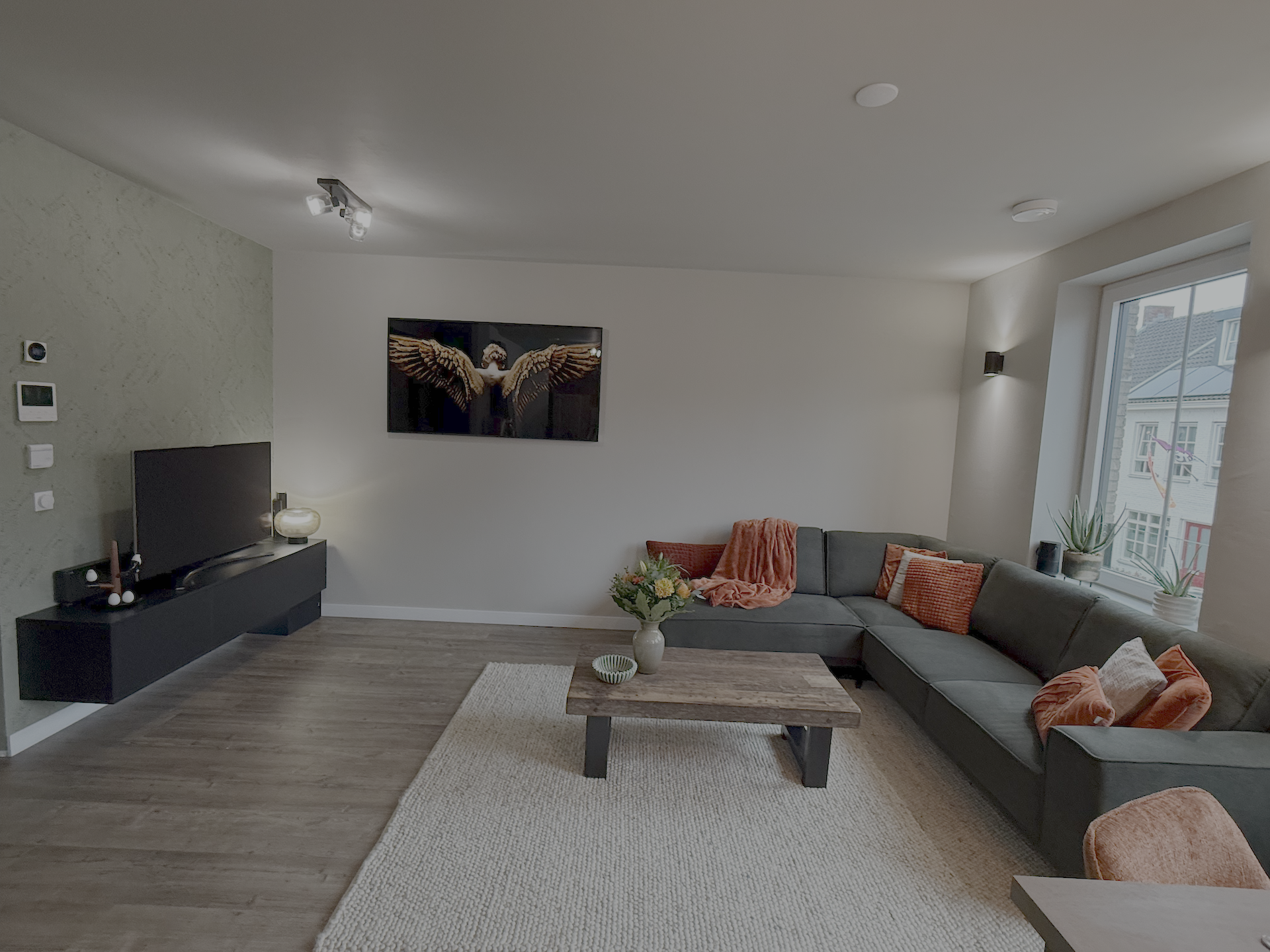 Woonkamer met saliegroen behang en mooie terracotta accenten